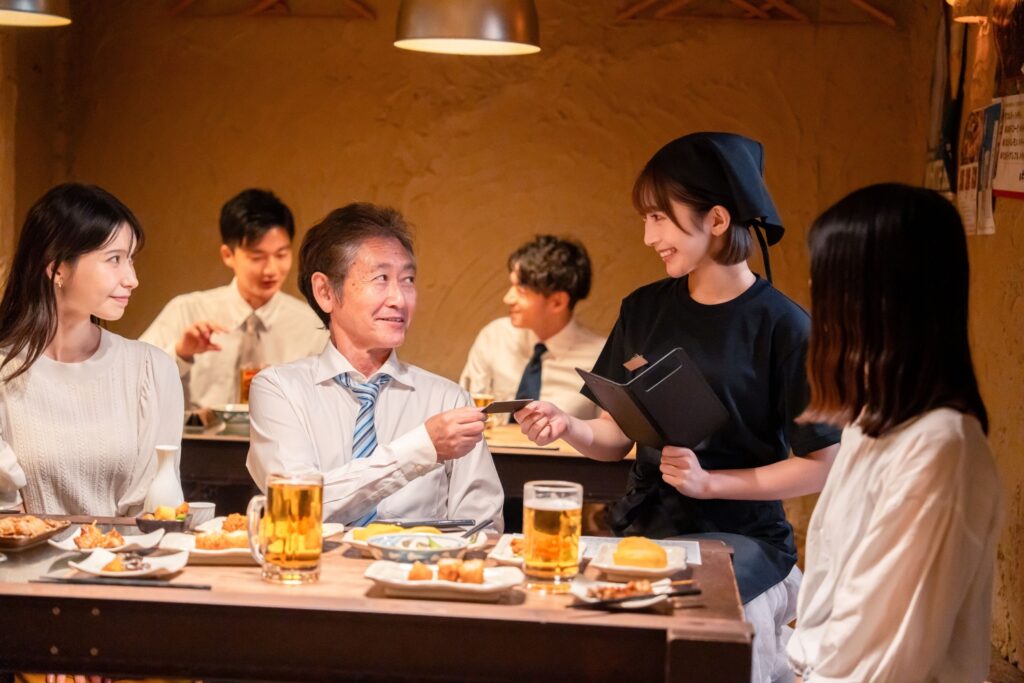 居酒屋でキャッシュレス決済をする男性客